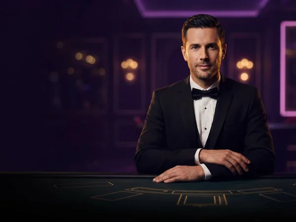 Lobby-style demo game card: portrait crop of the croupier at a dark green studio table